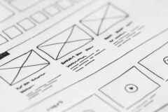 Schetsmatige UX wireframes van een website met lay-outblokken en contentstructuur op papier