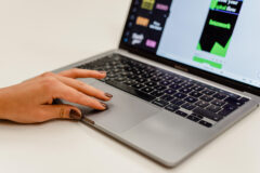 Hand op laptop tijdens het werken aan een website redesign